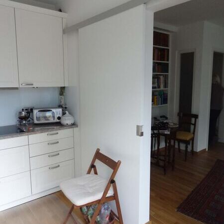 Weißlack-Schiebetür mit Design-Griff, vor der Wand laufend, Ansicht Küchenseite