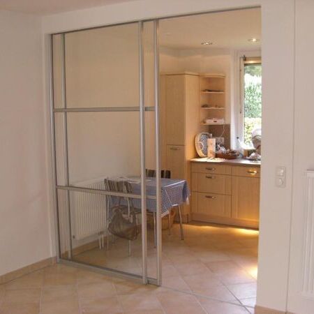 Gleitschiebetüranlage aus Glas, in Alurahmen und mit feststehendem Seitenteil, mit verdeckter Schiene