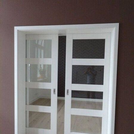 In die Wand laufende, 2-flügelige Schiebetür in Weißlack mit Glasausschnitten