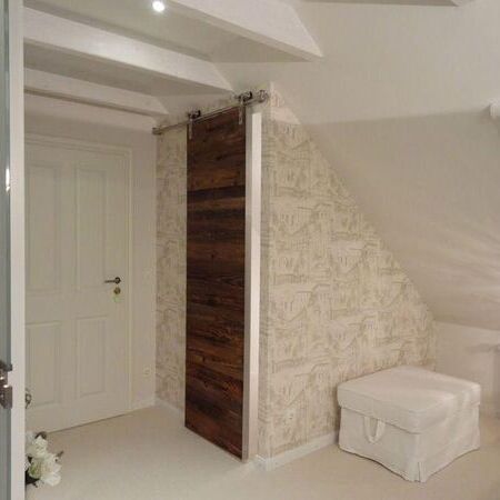 Schiebetür aus Altholz, Design-Y-Rollenbeschlag aus Edelstahl, Kantenabschluss mit Griffleiste gleichfalls aus Edelstahl